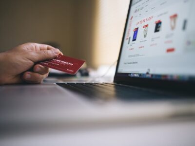 Black and Gray Laptop Computer With Turned-on Screen Beside Person Holding Red Smart Card in Selective-focus Photography